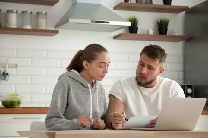 Young professional couple comparing bills